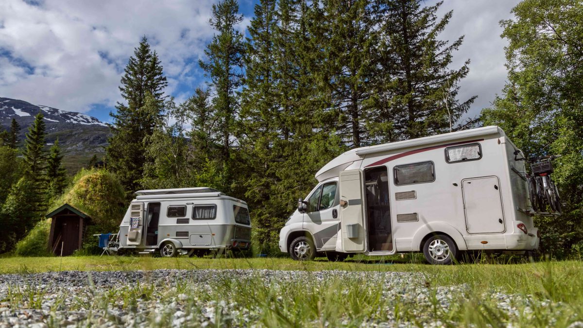 Ein Wohnmobil und ein Wohnwagen auf einem grünen Stellplatz
