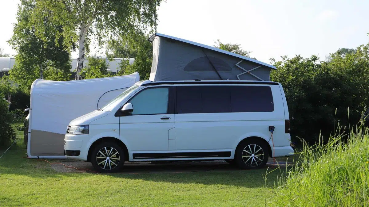 Ein VW-Bus mit einem Vorzelt.